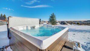 A hot tub in a snowy outdoor setting with a clear sky.