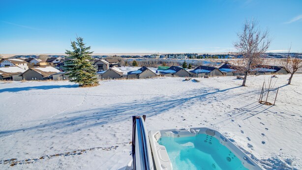 Paisaje nevado con piscina, casas y cielo despejado.