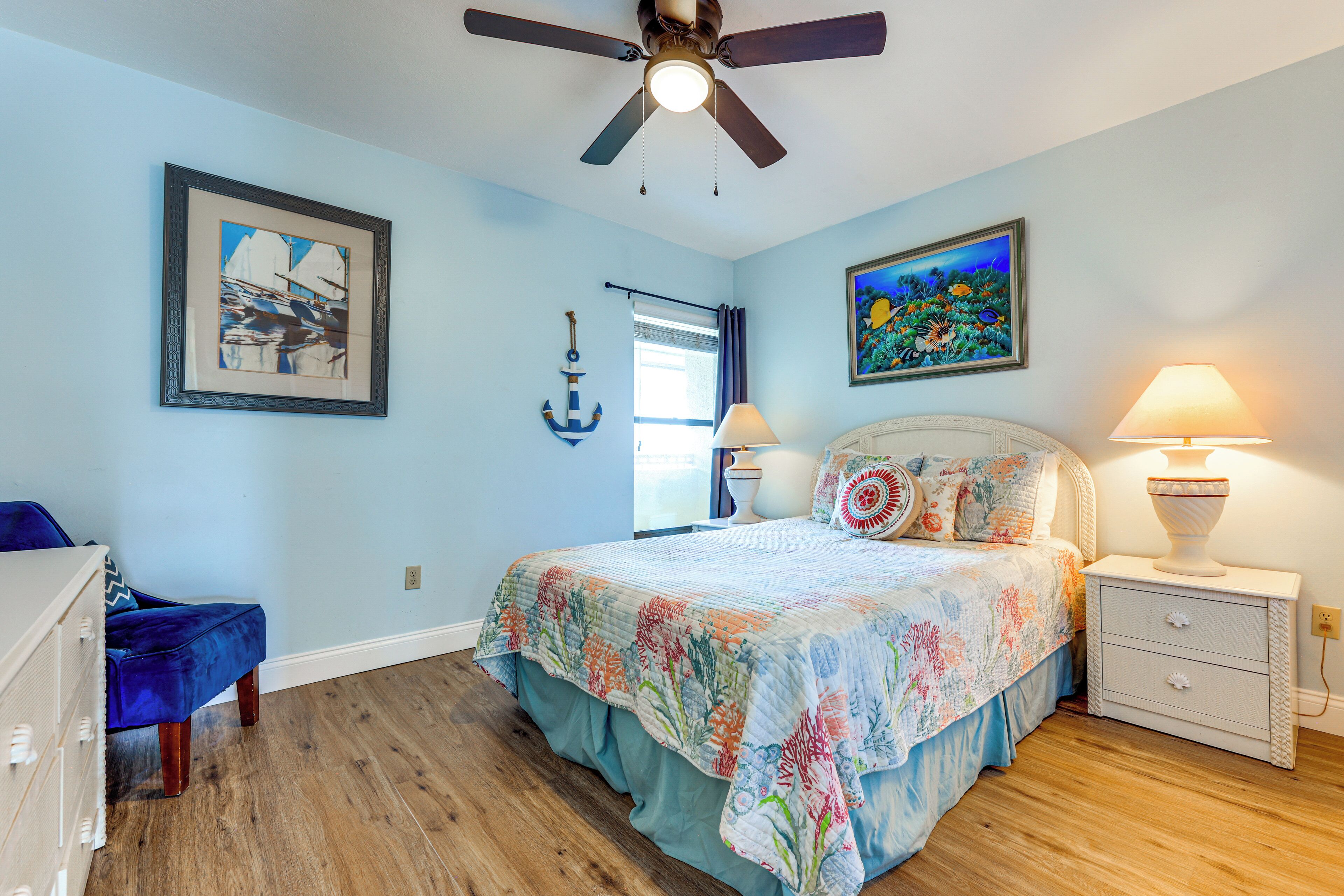 A bedroom with a bed, nightstands, a dresser, and a ceiling fan.