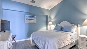 A bedroom with a bed, bedside lamps, a dresser, and a painting on the wall. - Walk to Beaches & Restaurants: Ocean City Condo (Ocean City)