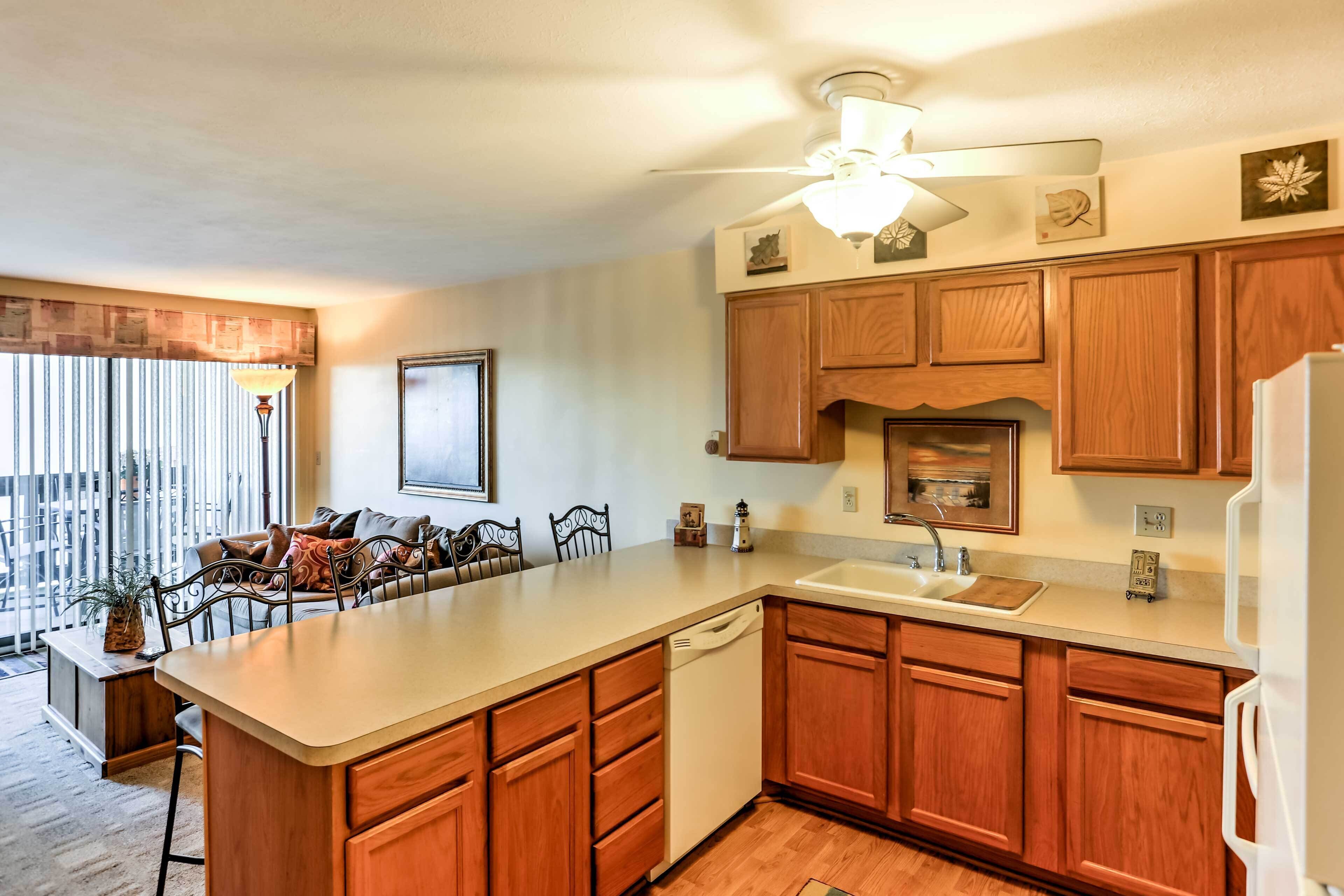 A kitchen with wooden cabinets, a white dishwasher, and a large island.