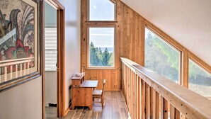 A wooden interior with a dining area, large windows, and a view of trees. - Hood Canal Home w/ Hot Tub - Bordering Olympic NP! (Brinnon)