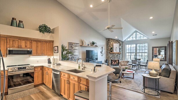 A spacious kitchen with wooden cabinets, a central island, and a large window. - Indoor Pool & Golf Course Views: Lake Lure Condo! (Lake Lure)