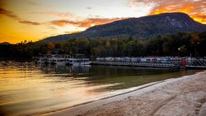 A waterfront with a dock, boats, and a mountain in the background. - Indoor Pool & Golf Course Views: Lake Lure Condo! (Lake Lure)