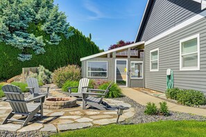 A patio with Adirondack chairs, a fire pit, and a garden with various plants and trees. - Remarkable Yakima Getaway w/ Pool & Hot Tub! (Yakima)