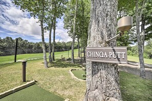 A sign reading "CHINQA-PUTT" attached to a tree in a park-like setting with a golf course in the background. - Hike, Fish & Golf! Serene Mtn Retreat in Glenville (Glenville)