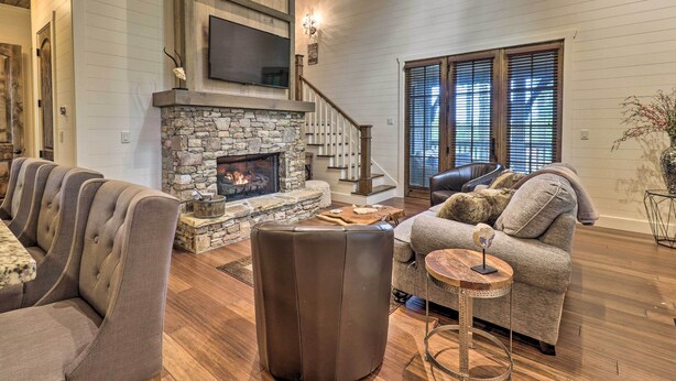 A cozy living room with a stone fireplace, a large TV mounted above it, and a comfortable seating area with a sofa and chairs. - Hike, Fish & Golf! Serene Mtn Retreat in Glenville (Glenville)