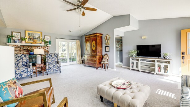 A spacious living room with a large ceiling fan, a fireplace, a television, and a variety of seating options including a sofa and an ottoman. - Pleasant Valley Wine Trail Home - Near Paso Robles (San Miguel)