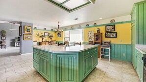 A kitchen with a large island, green cabinets, and a skylight. - Pleasant Valley Wine Trail Home - Near Paso Robles (San Miguel)