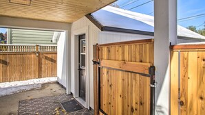 Un porche abrité, doté d’une clôture en bois, d’une porte et d’une porte de garage.