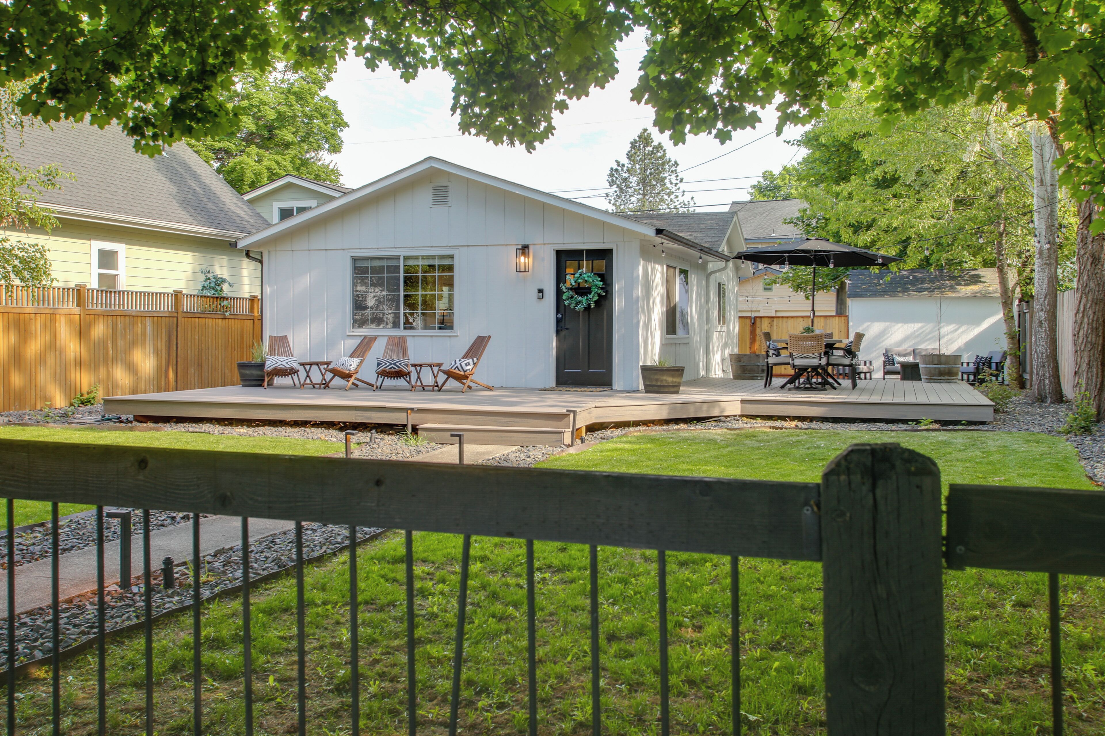 A house with a deck, outdoor furniture, and a fenced yard.