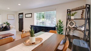Un espace repas comprenant une table en bois, des chaises et un buffet.
