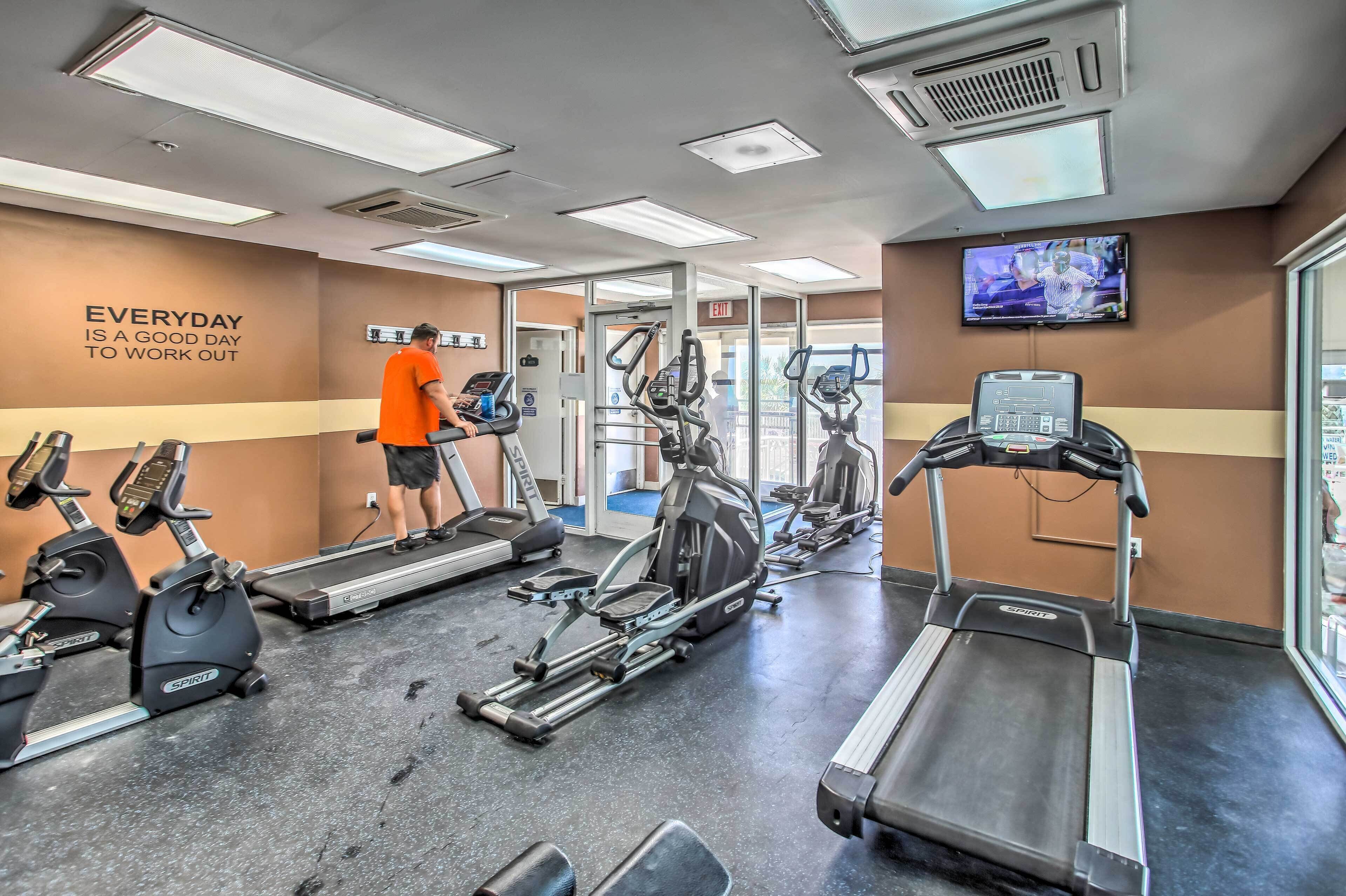 A gym with treadmills, stationary bikes, and elliptical machines.