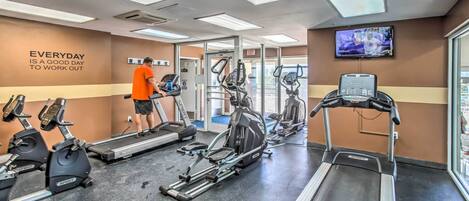 A gym with treadmills, stationary bikes, and elliptical machines.