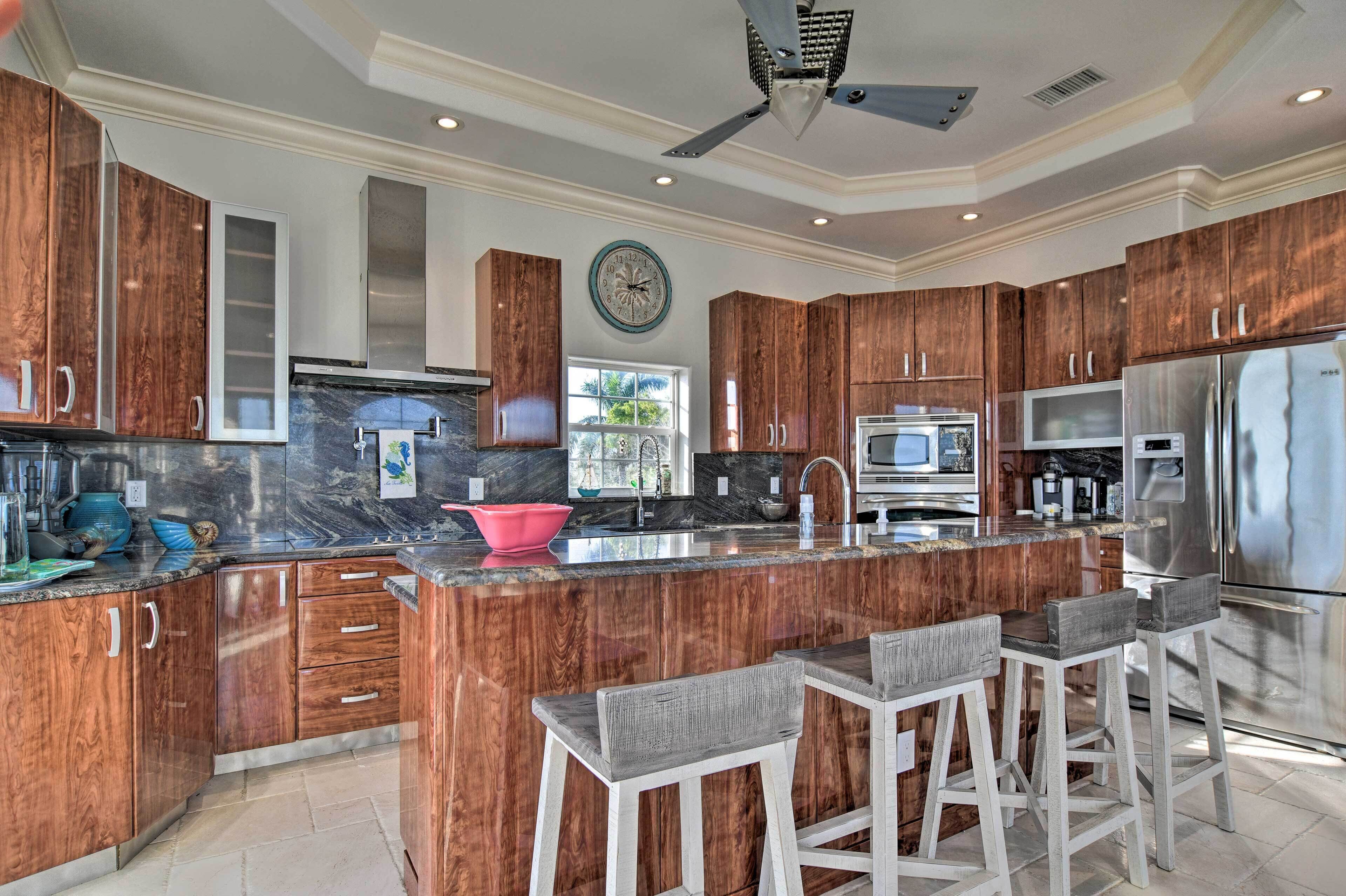 A modern kitchen with wooden cabinets, stainless steel appliances, and a central island with bar stools.