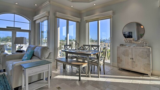 A spacious living area with a dining table, cushioned seating, and a view of the outdoors. - Bradenton Townhome - Walk to Locals-only Beach! (Bradenton Beach)