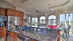 A spacious kitchen with granite countertops, stainless steel appliances, and wooden cabinets. - Bradenton Townhome - Walk to Locals-only Beach! (Bradenton Beach)