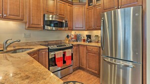 A kitchen with wooden cabinets, stainless steel appliances, granite countertops, and a built-in oven. - Townhome w/ Grill < 1 Mi to Big Boulder Mountain (Lake Harmony)