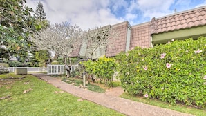 A residential area with a well-maintained lawn, a pathway, and a white picket fence. - Coastal Escape Condo w/ Pool, Near Beaches! (Princeville)