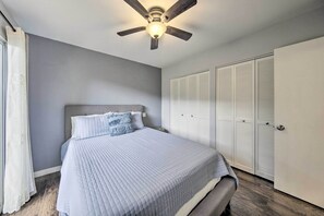 A bedroom with a bed, a ceiling fan, and a wardrobe.