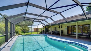 Una piscina techada con una fuente de agua azul cristalina, rodeada por una terraza con mobiliario exterior.