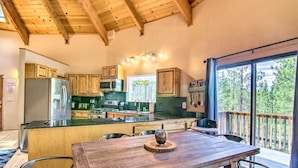 A modern kitchen with wooden cabinets, a stainless steel refrigerator, and a large island with seating. - 'zen Forest Mountain Retreat' Tahoe Home W/hot Tub (South Lake Tahoe)