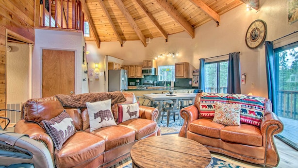 A spacious living area with leather sofas, a wooden coffee table, and a kitchen in the background. - 'zen Forest Mountain Retreat' Tahoe Home W/hot Tub (South Lake Tahoe)