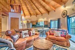 A spacious living area with leather sofas, a wooden coffee table, and a kitchen in the background. - 'zen Forest Mountain Retreat' Tahoe Home W/hot Tub (South Lake Tahoe)