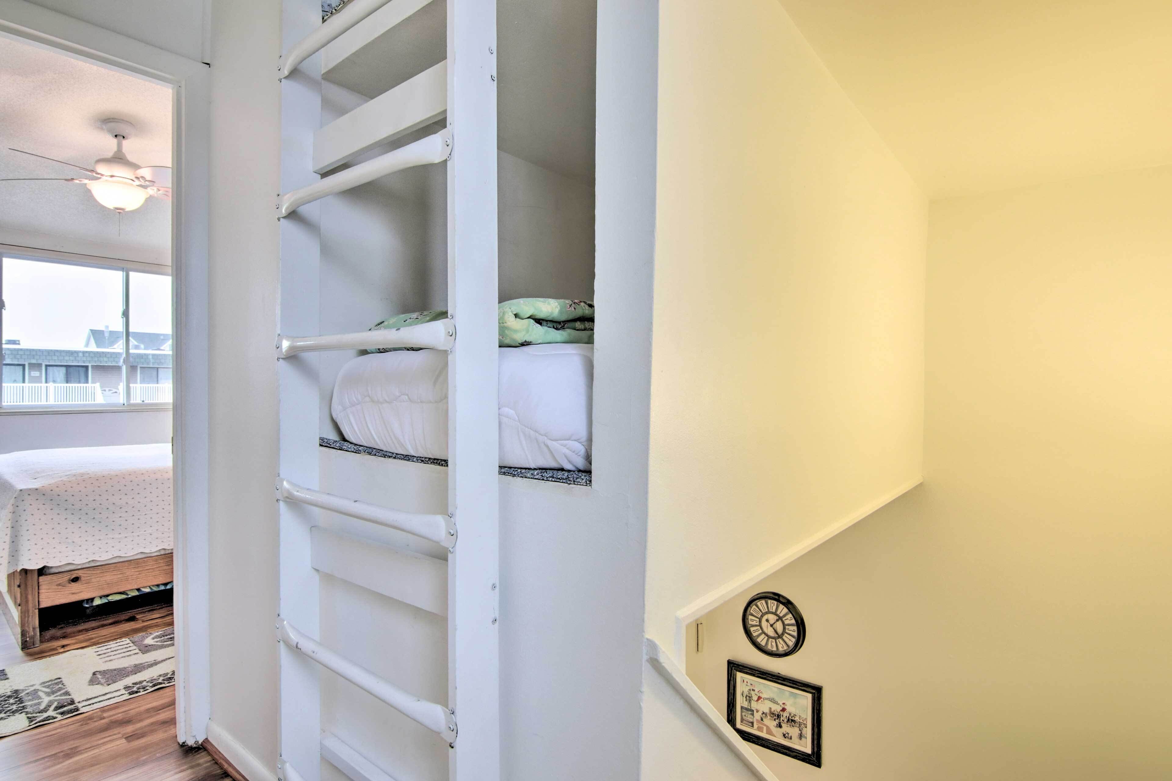 Un dormitorio con una cama, un armario blanco, un reloj y un cuadro en la pared.
