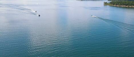 A large body of water with several boats creating wake patterns.