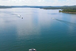 A large body of water with several boats creating wake patterns.
