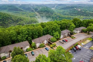 A residential area with houses, a parking lot, and a view of a valley.