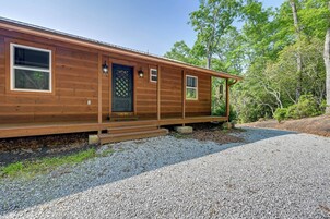 A wooden cabin with a front porch, a door with a decorative pattern, and windows.