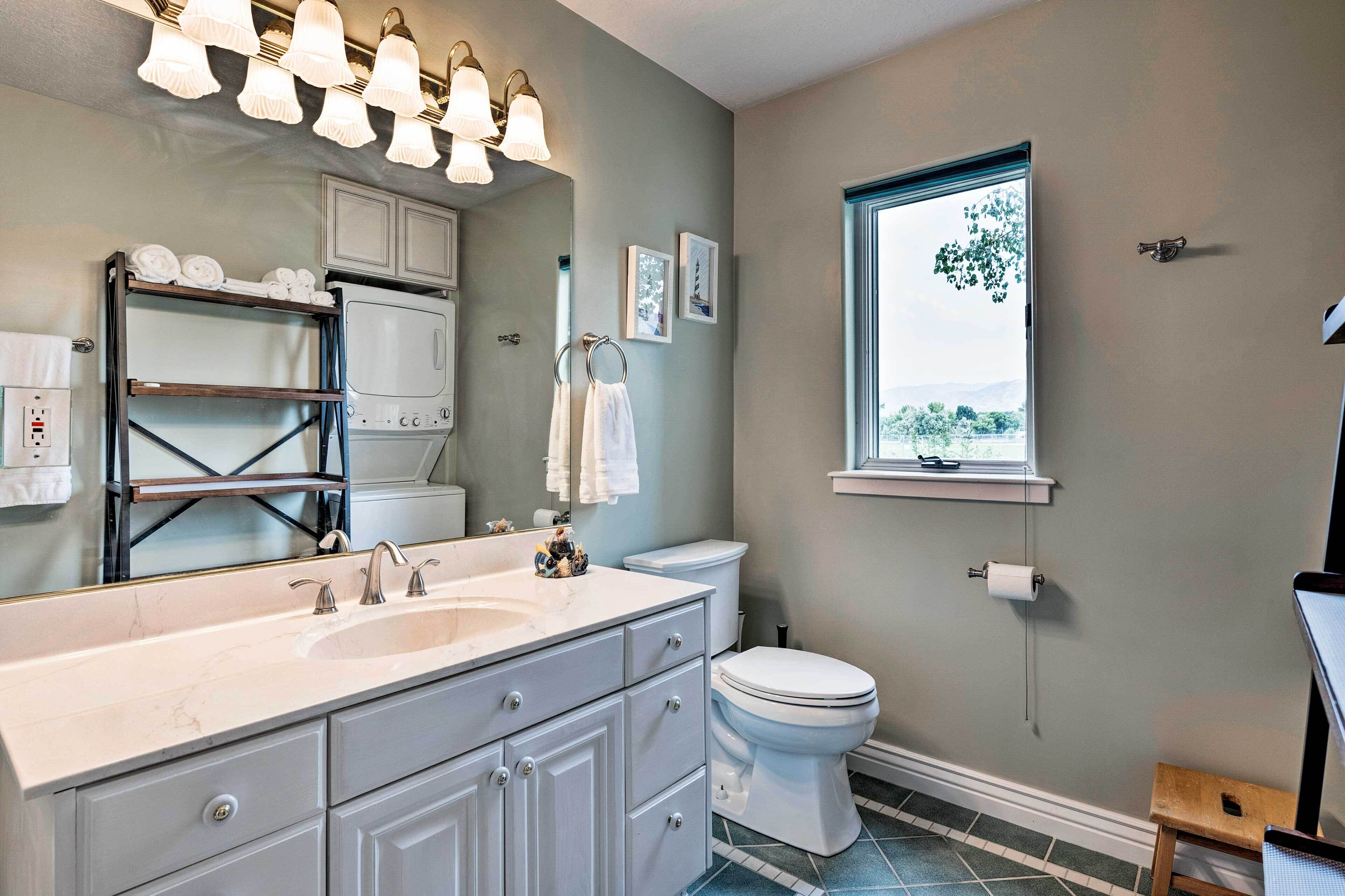 A bathroom with a large sink, toilet, and a window with a view.