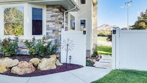 A residential house with a stone facade, large windows, and a well-maintained garden with rocks and plants. - Mtn-view SLC Apt w/ Patio Near Downtown (Salt Lake City)