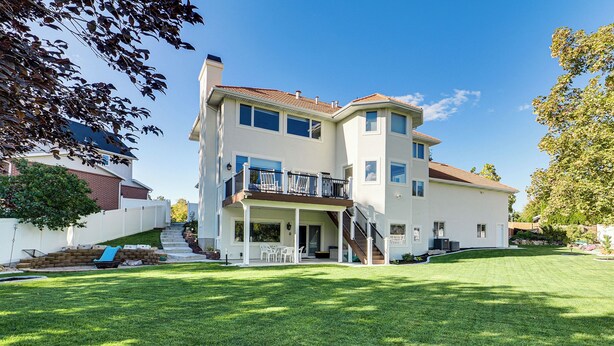 A two-story house with a covered patio, a small deck, and a well-maintained lawn. - Mtn-view SLC Apt w/ Patio Near Downtown (Salt Lake City)