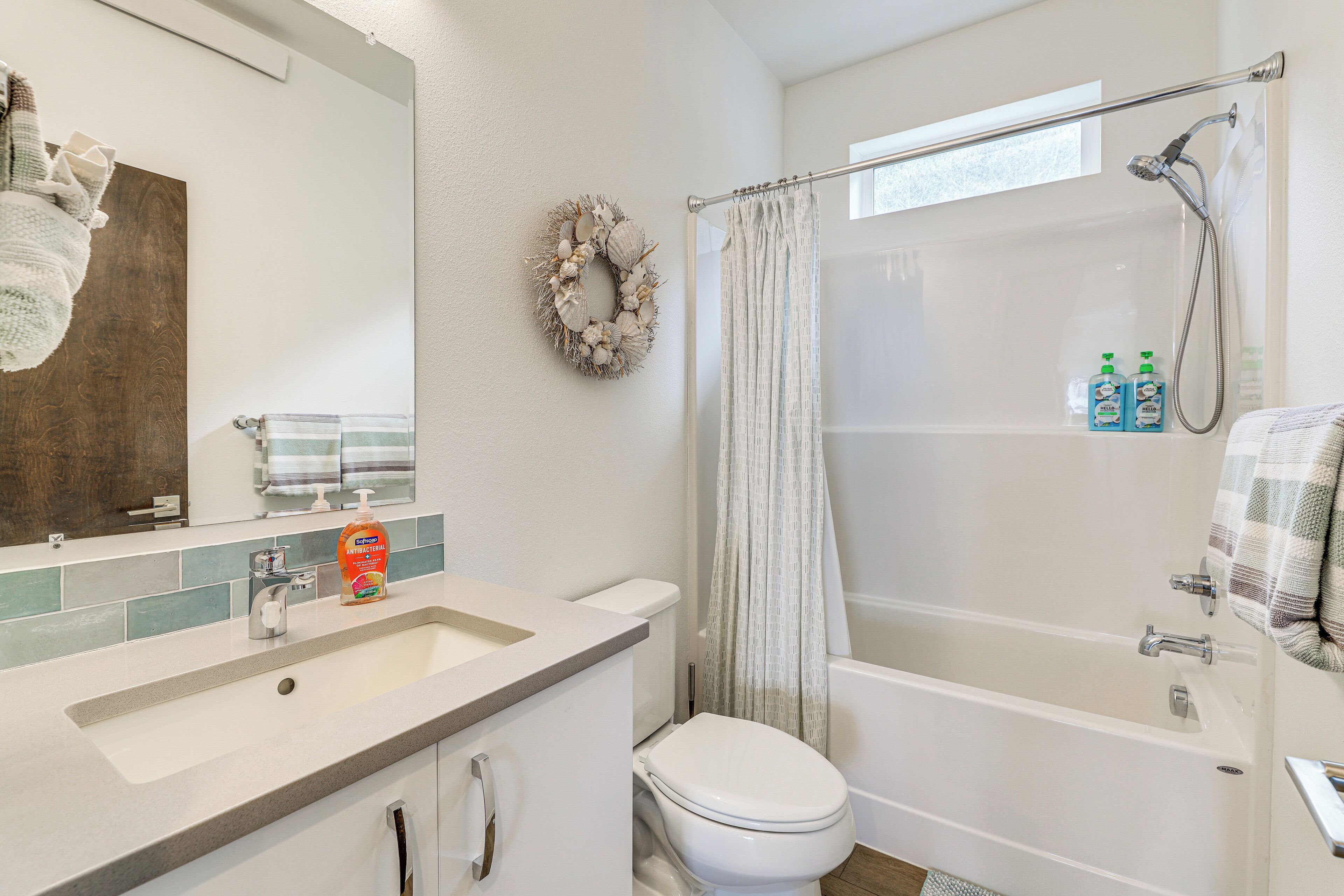 A bathroom with a white sink, toilet, and bathtub.