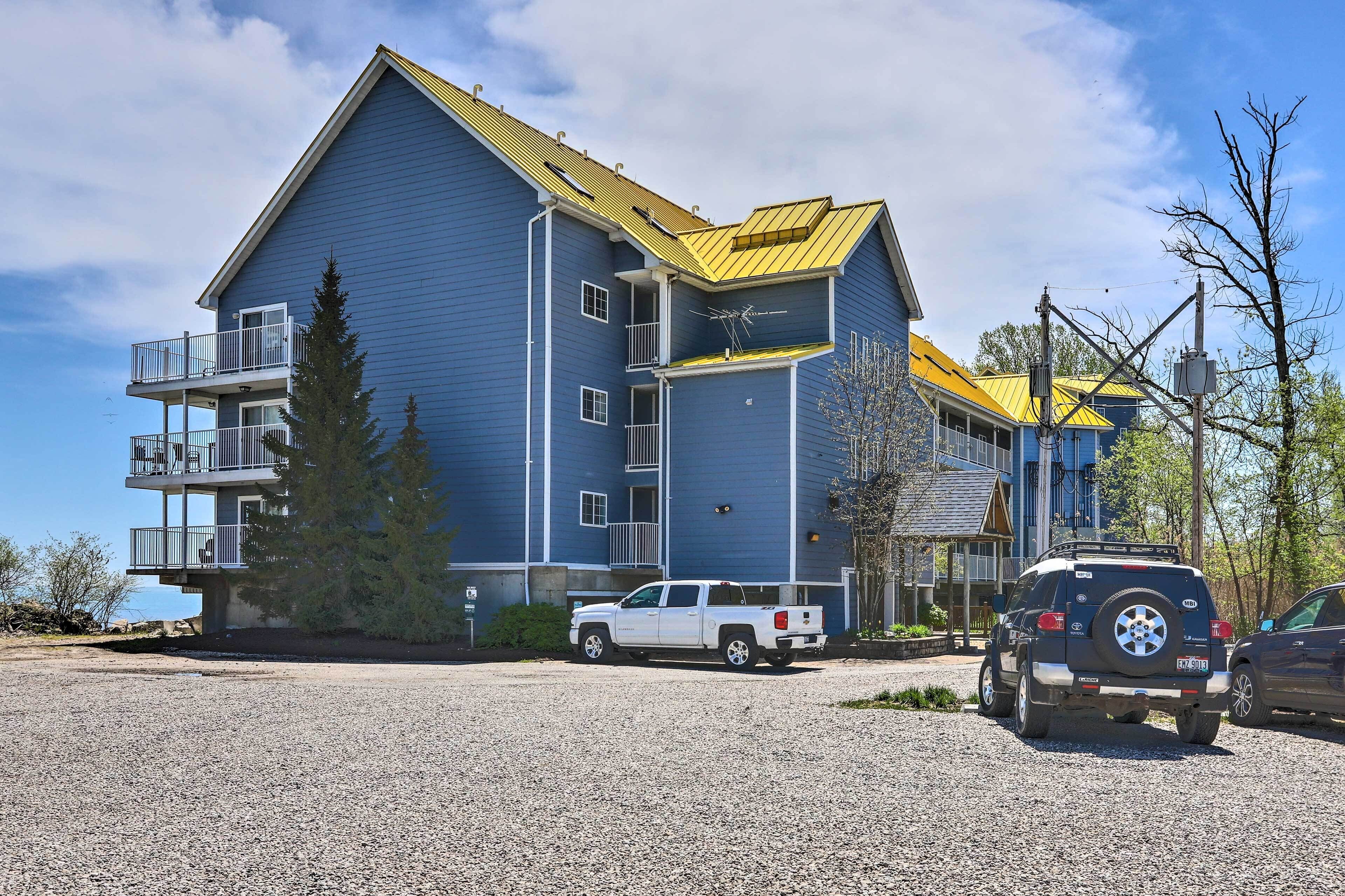 A two-story building with a blue exterior and a yellow roof, featuring a balcony on the upper floor.
