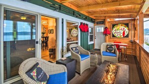 A wooden interior with wicker furniture, a grill, and a view of the outdoors. - Fish, Crab & Clam: Waterfront Gem in Port Ludlow (Port Ludlow)