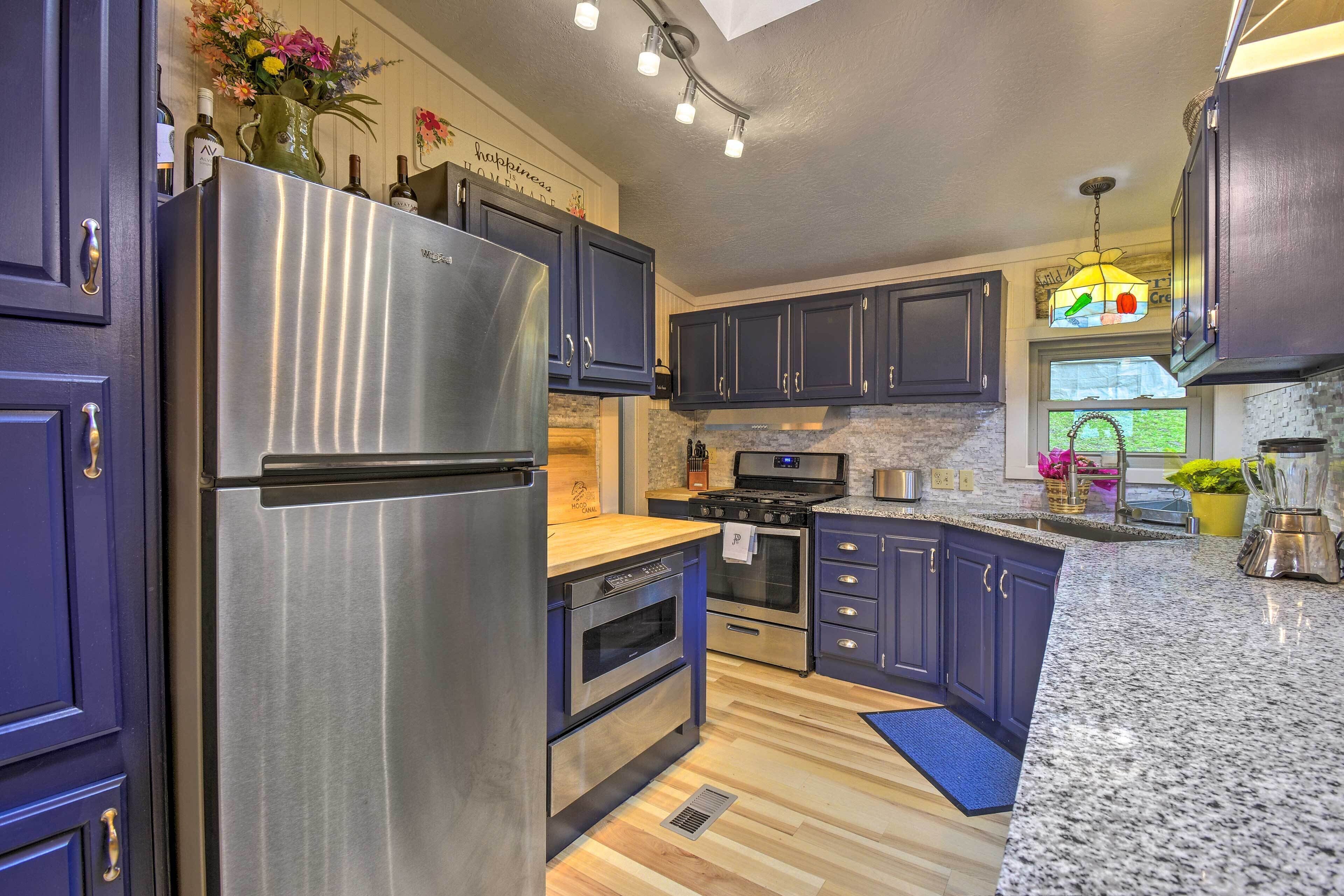 A modern kitchen with dark cabinets, stainless steel appliances, and granite countertops.