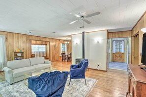 A spacious living room with a sofa, armchairs, a television, and a fireplace. - Secluded Franklin Cabin w/ Furnished Deck! (Franklin)