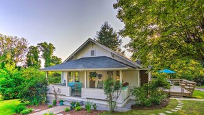 A two-story house with a covered porch, a small deck, and a well-maintained garden. - Restored Mars Hill Home on 1 Acre: Walk to Town! (Mars Hill)