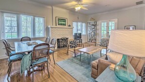 A dining area with a wooden table and chairs, a fireplace, and a bookshelf. - Chic Ocala Home w/ Yard ~ 1 Mi to Dtwn Square (Ocala)