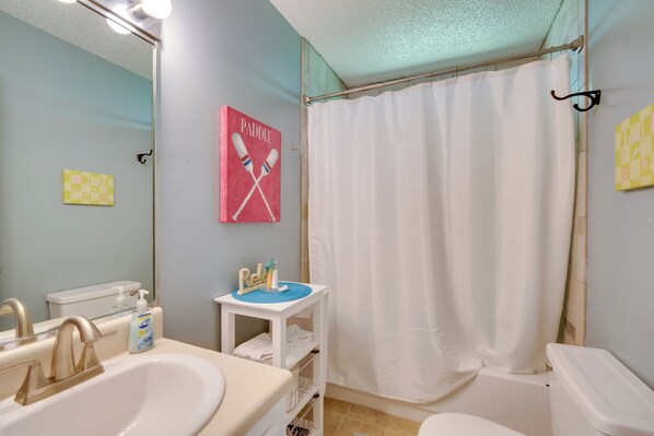 A bathroom with a sink, toilet, and shower curtain. - Docks + Balcony: Peaceful River Abode in Dunnellon (Dunnellon)