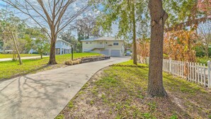 A residential property with a driveway, a detached garage, and a lawn. - Withlacoochee River House w/ Dock + Kayaks! (Inglis)