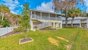 A two-story house with a covered porch and a staircase leading to the upper floor. - Withlacoochee River House w/ Dock + Kayaks! (Inglis)