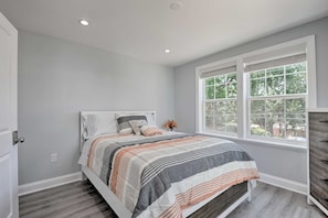 Une chambre à coucher avec un lit, une fenêtre et une commode.