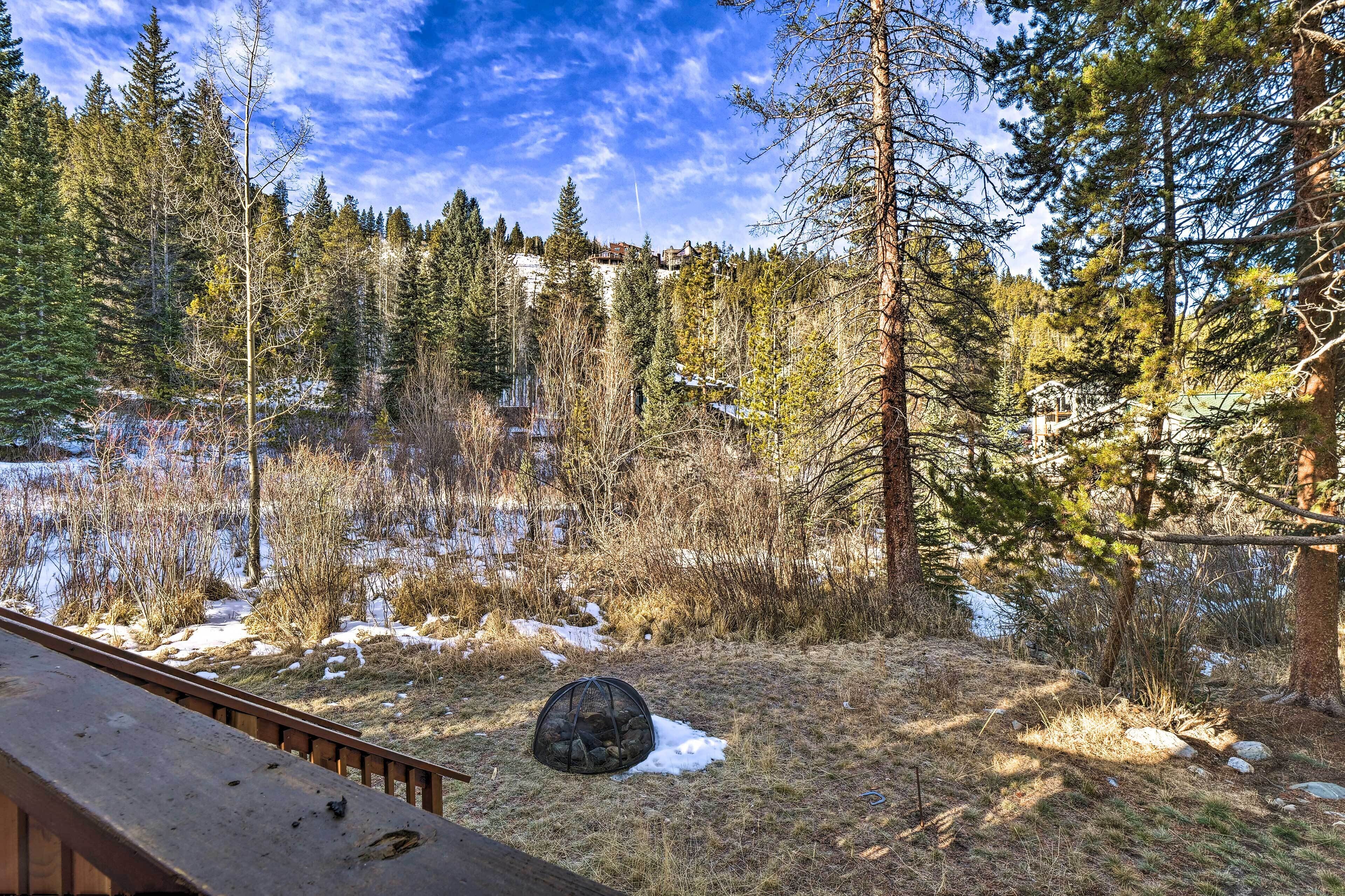 A forested area with a wooden deck overlooking a snowy landscape.