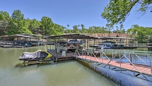 A marina with docked boats, covered seating areas, and a small dock extending into the water.