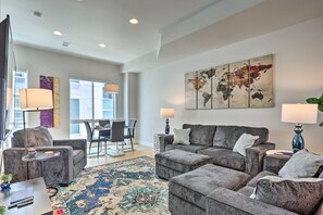 A modern living room with grey sofas, a coffee table, and a world map artwork on the wall. - Trendy Denver Townhome - Walk to Mile High Stadium (Denver)